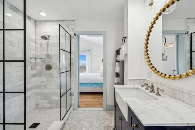 a bathroom with a granite countertop shower a sink and a mirror