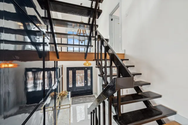 a view of staircase with lots of frames on wall and a window
