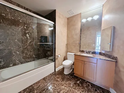 a bathroom with a bathtub shower sink mirror and toilet
