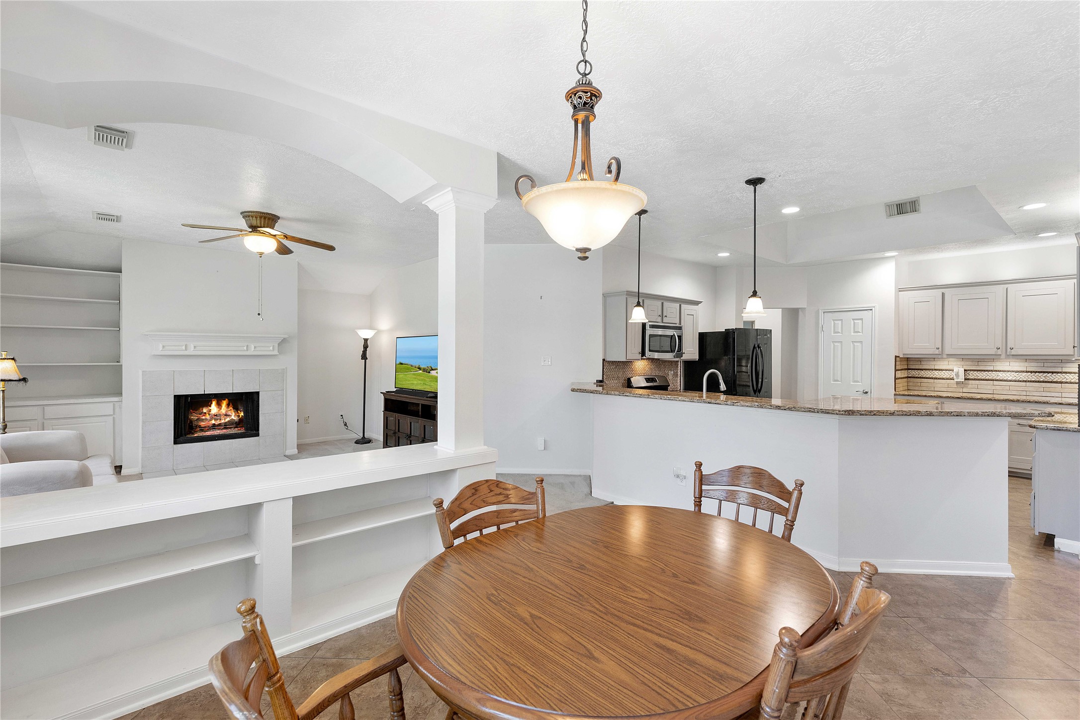 1707 Moston Drive Spring, TX 77386 - Photo 17 of 41 a kitchen with a table chairs refrigerator and microwave