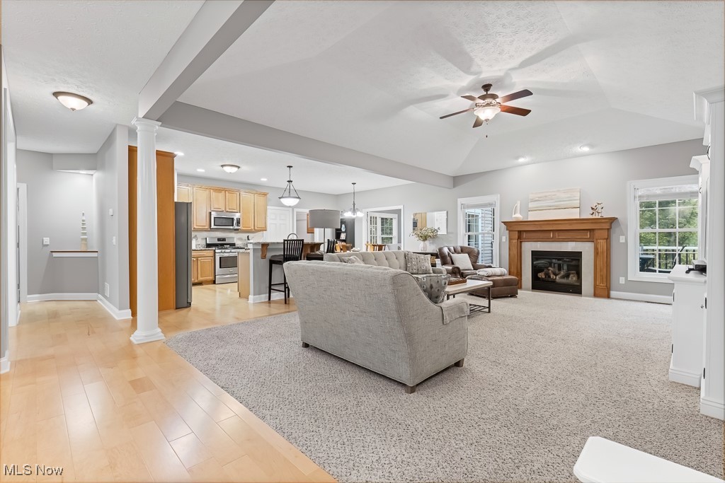 369 Eldridge Road Aurora, OH 44202 - Photo 5 of 50 Living room with ornate columns, a ceiling fan, a fireplace, recessed lighting, and light wood-style floors
