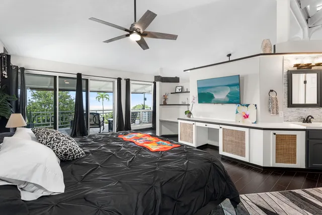 a bedroom with a bed a large window and flat screen tv