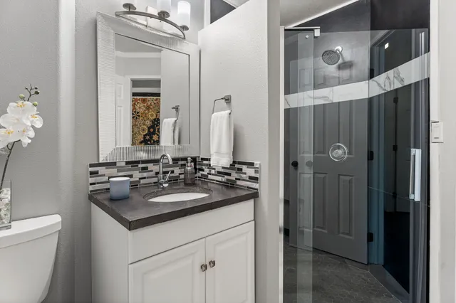 a bathroom with a sink and a mirror with toilet