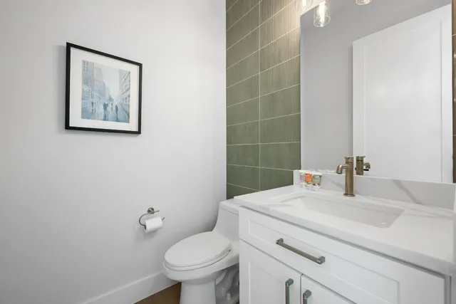 a bathroom with a granite countertop sink mirror vanity and toilet