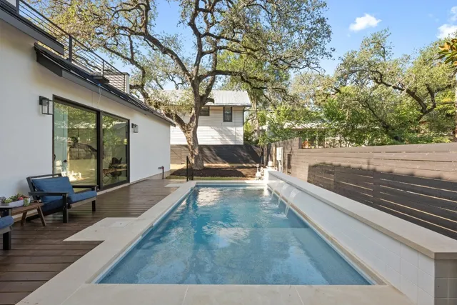 a view of a house with pool and sitting area