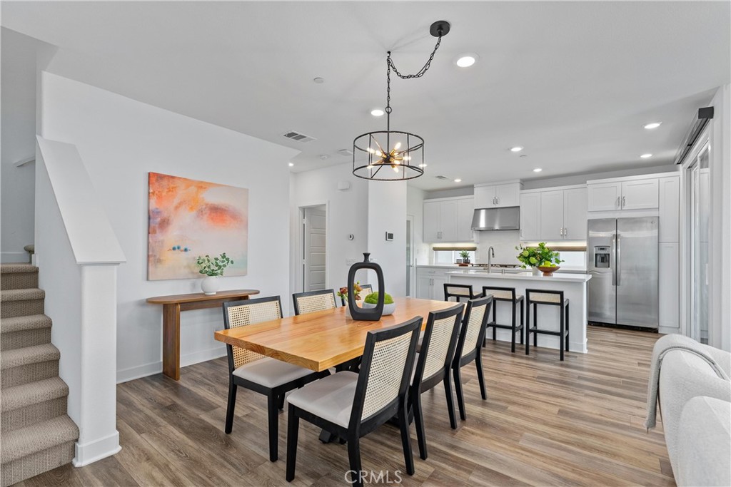 303 Lodestar Tustin, CA 92782 - Photo 14 of 37 a dining room with furniture a rug a chandelier and wooden floor