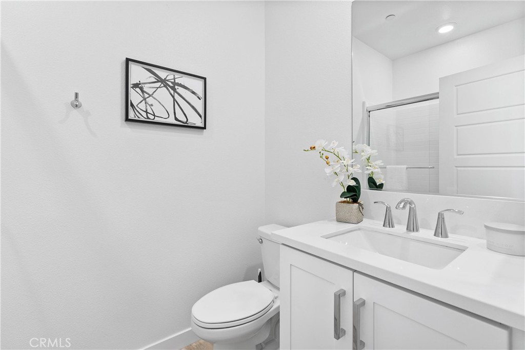 303 Lodestar Tustin, CA 92782 - Photo 26 of 37 a bathroom with a toilet sink and mirror