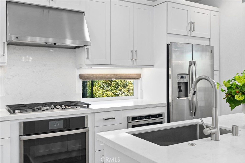 303 Lodestar Tustin, CA 92782 - Photo 8 of 37 a kitchen with granite countertop a stove and a sink