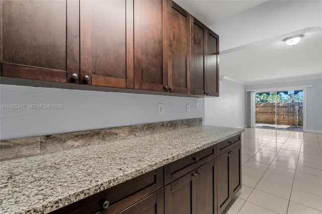 a kitchen with granite countertop a sink and a wooden cabinets