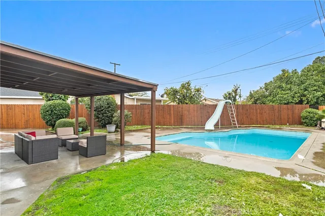 a view of a backyard with table and chairs potted plants and wooden fence