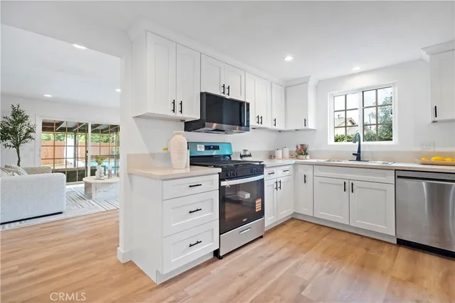 a kitchen with white cabinets and white appliances
