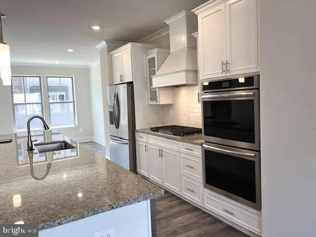 a kitchen with stainless steel appliances granite countertop a stove a sink and a refrigerator