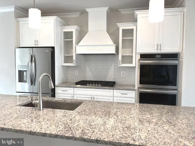 a kitchen with granite countertop a stove and a refrigerator
