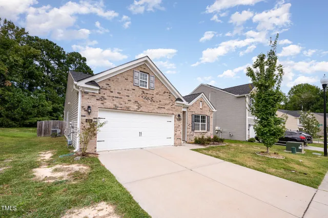a front view of a house with a garden and yard