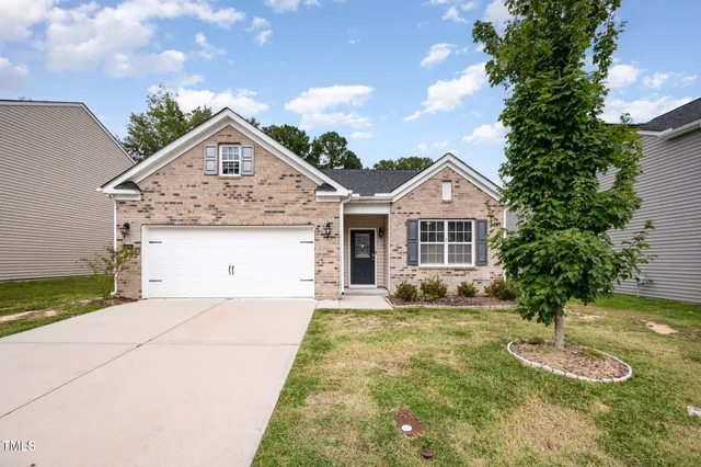a front view of a house with a yard and garage