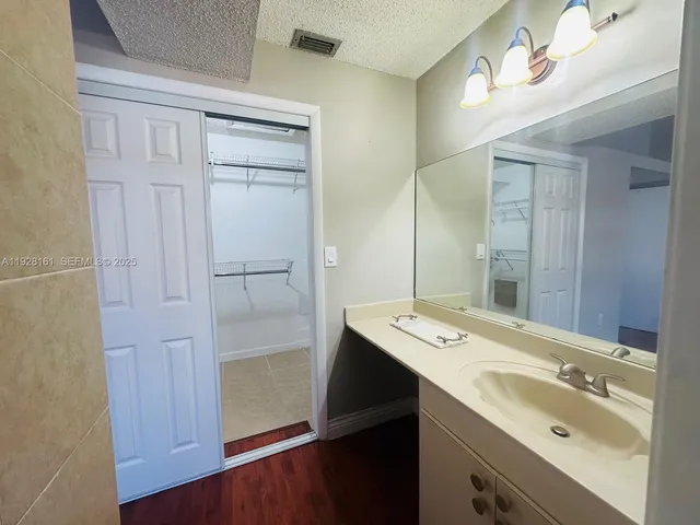 a bathroom with a sink a mirror and a shower