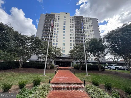 a front view of a multi story building with yard