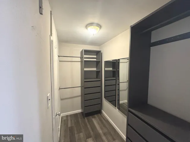 a view of walk in closet with empty racks