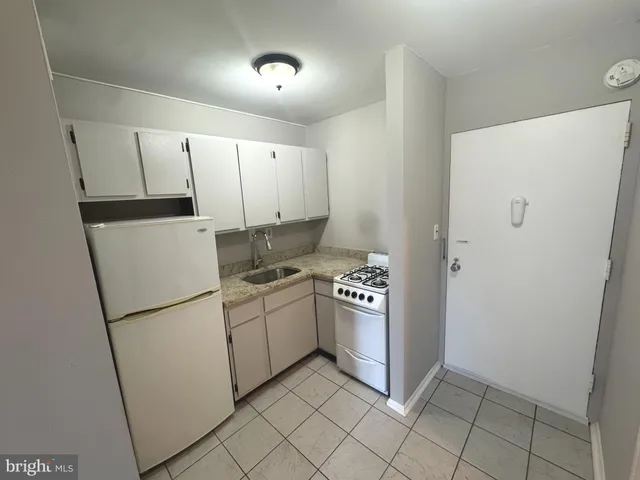 a kitchen with white cabinets and white appliances