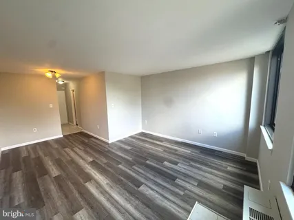 a view of empty room with wooden floor