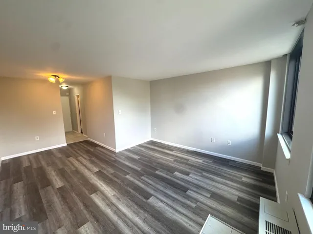 a view of empty room with wooden floor