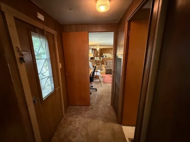 a view of a hallway and a livingroom with furniture