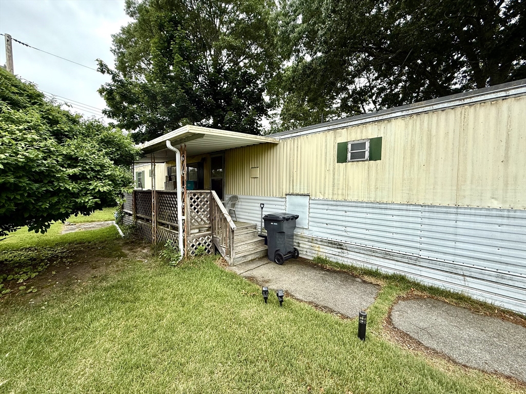 3132 Cranberry Highway, Unit 59 Wareham, MA 02538 - Photo 2 of 22 a backyard of a house with table and chairs