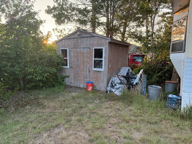 a view of a house with a yard and a tree