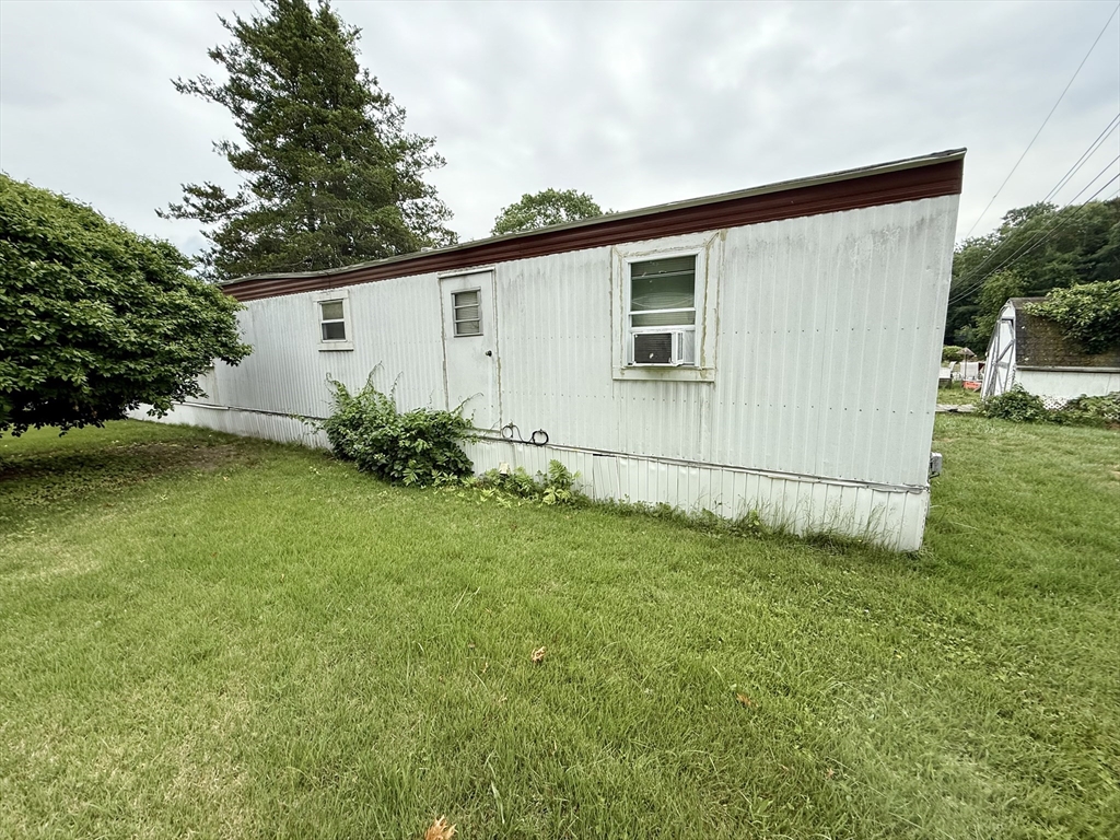 3132 Cranberry Highway, Unit 59 Wareham, MA 02538 - Photo 4 of 22 a view of a backyard with potted plants and large trees