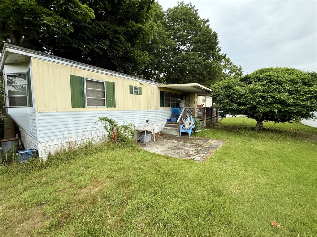 3132 Cranberry Highway, Unit 59 Wareham, MA 02538 - Photo 5 of 22 a view of a backyard with a table and chairs