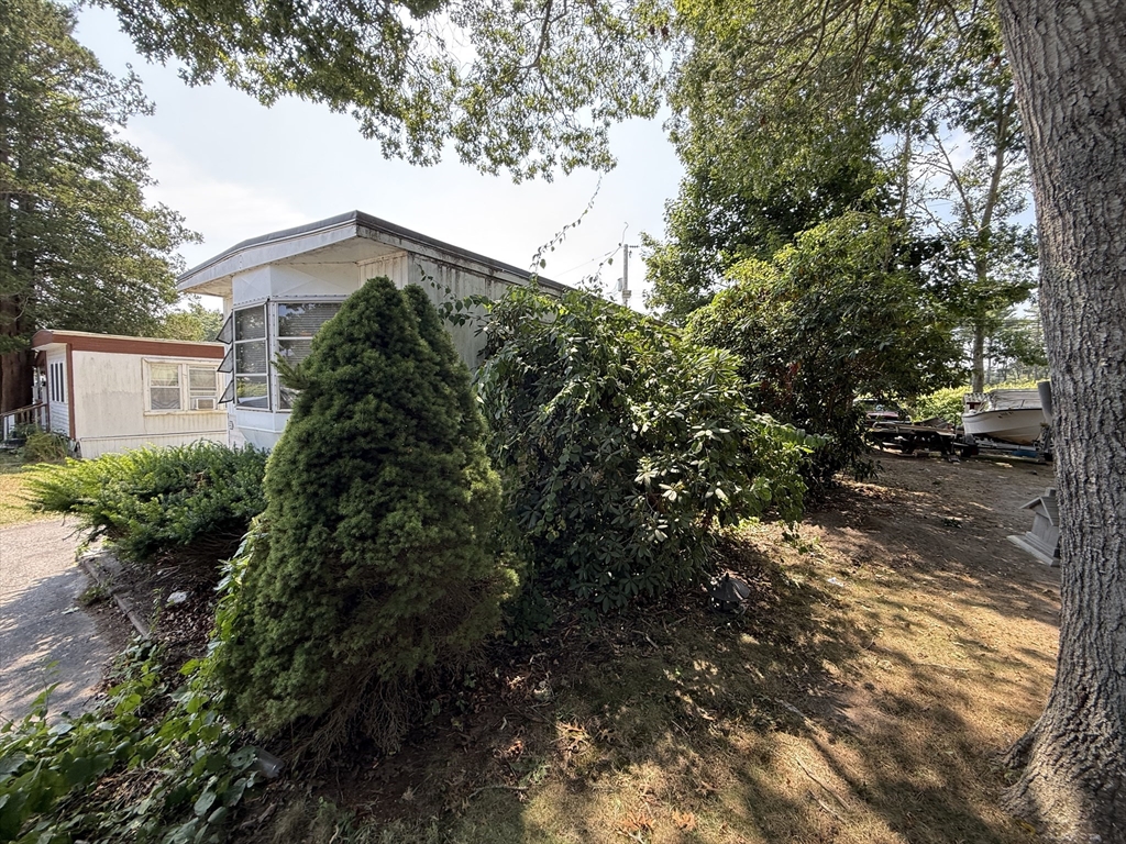3132 Cranberry Highway, Unit 59 Wareham, MA 02538 - Photo 7 of 22 a backyard of a house with lots of green space