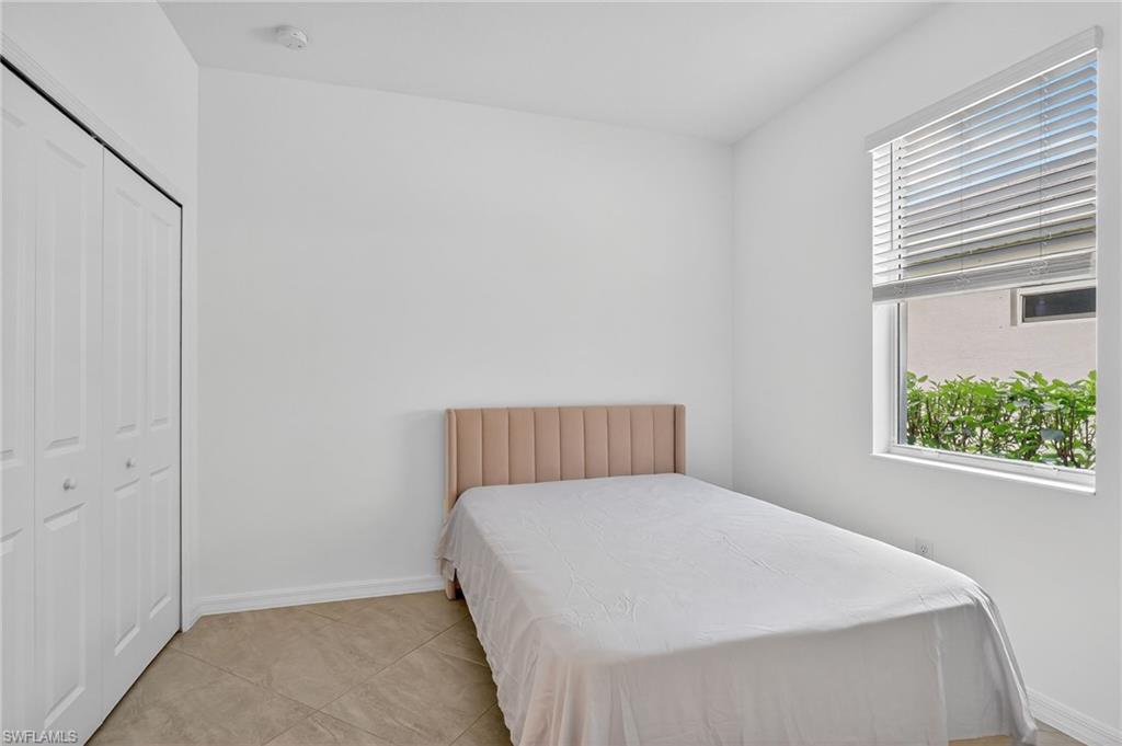 2126 Hamlin Street Naples, FL 34120 - Photo 19 of 38 a bed sitting in a bedroom next to a window