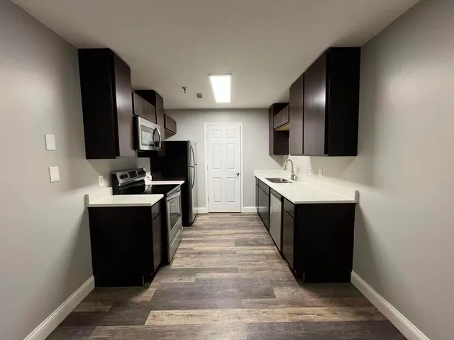 a large kitchen with a sink and stainless steel appliances