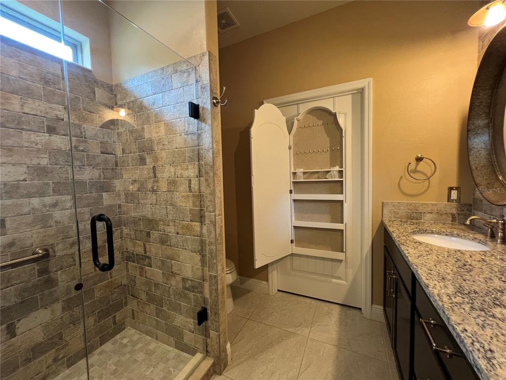 9515 Southwest 76th Street Ocala, FL 34481 - Photo 34 of 55 a bathroom with a granite countertop sink a vanity and a mirror