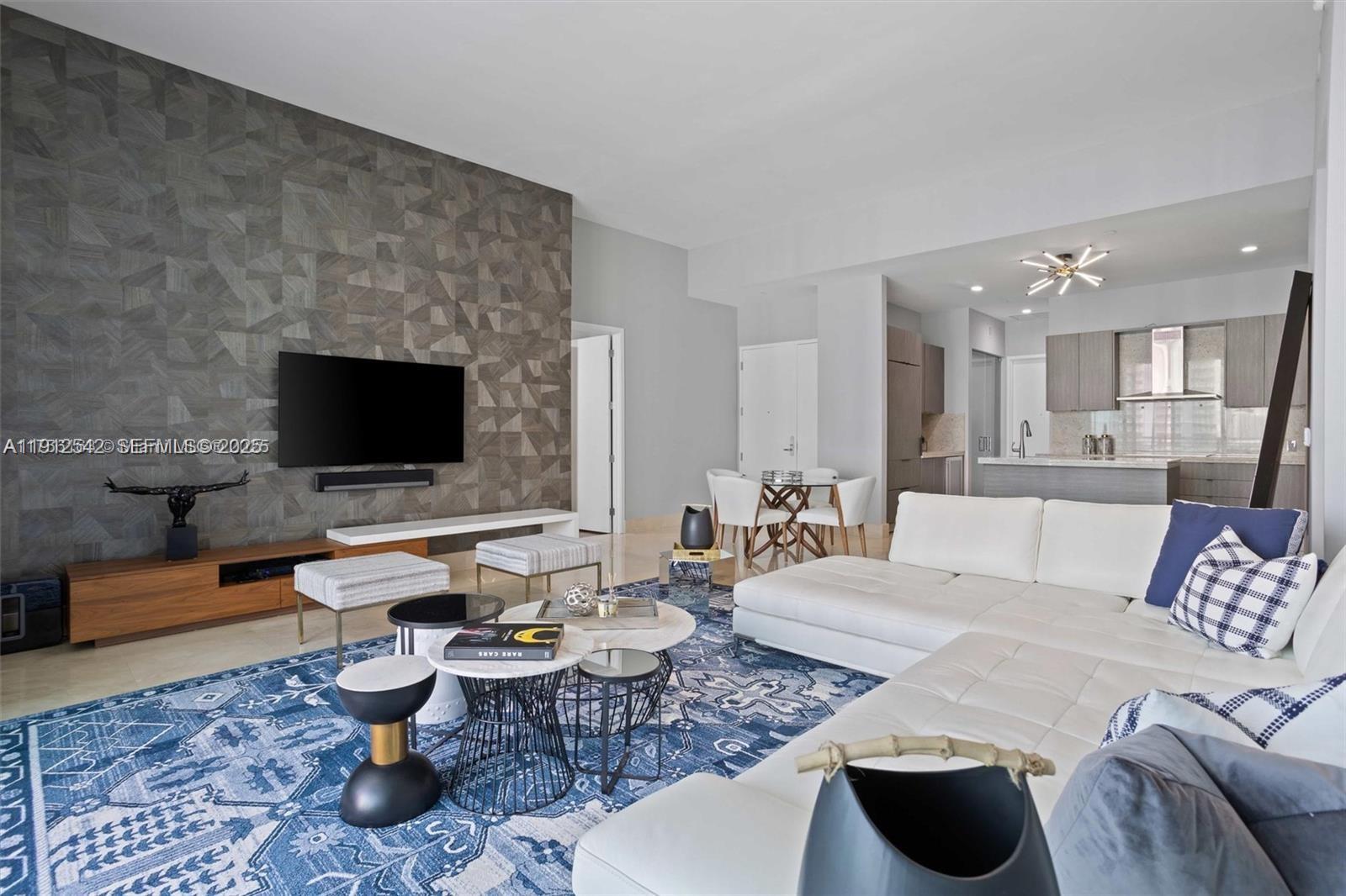 900 Brickell Key Boulevard, Unit 1502 Miami, FL 33131 - Photo 18 of 33 a living room with furniture and a flat screen tv