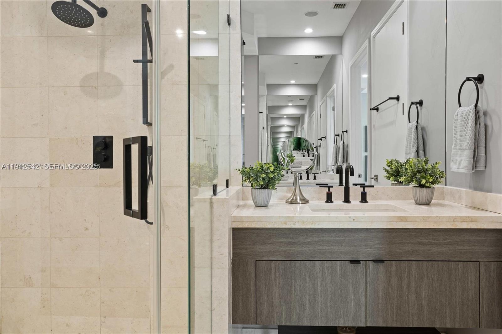 900 Brickell Key Boulevard, Unit 1502 Miami, FL 33131 - Photo 21 of 33 a bathroom with a sink and a mirror