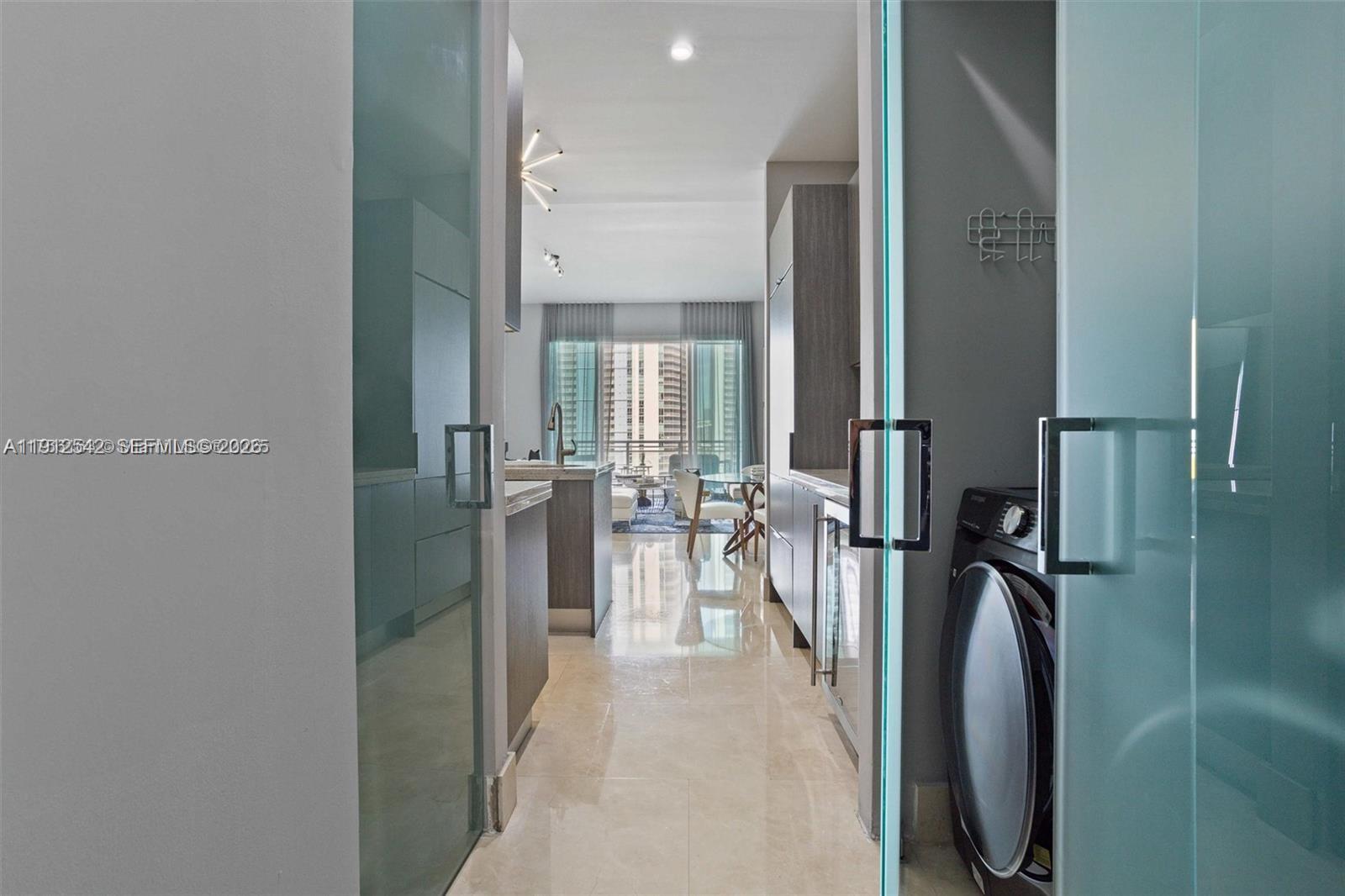 900 Brickell Key Boulevard, Unit 1502 Miami, FL 33131 - Photo 24 of 33 a view of a hallway with a couch and chandelier