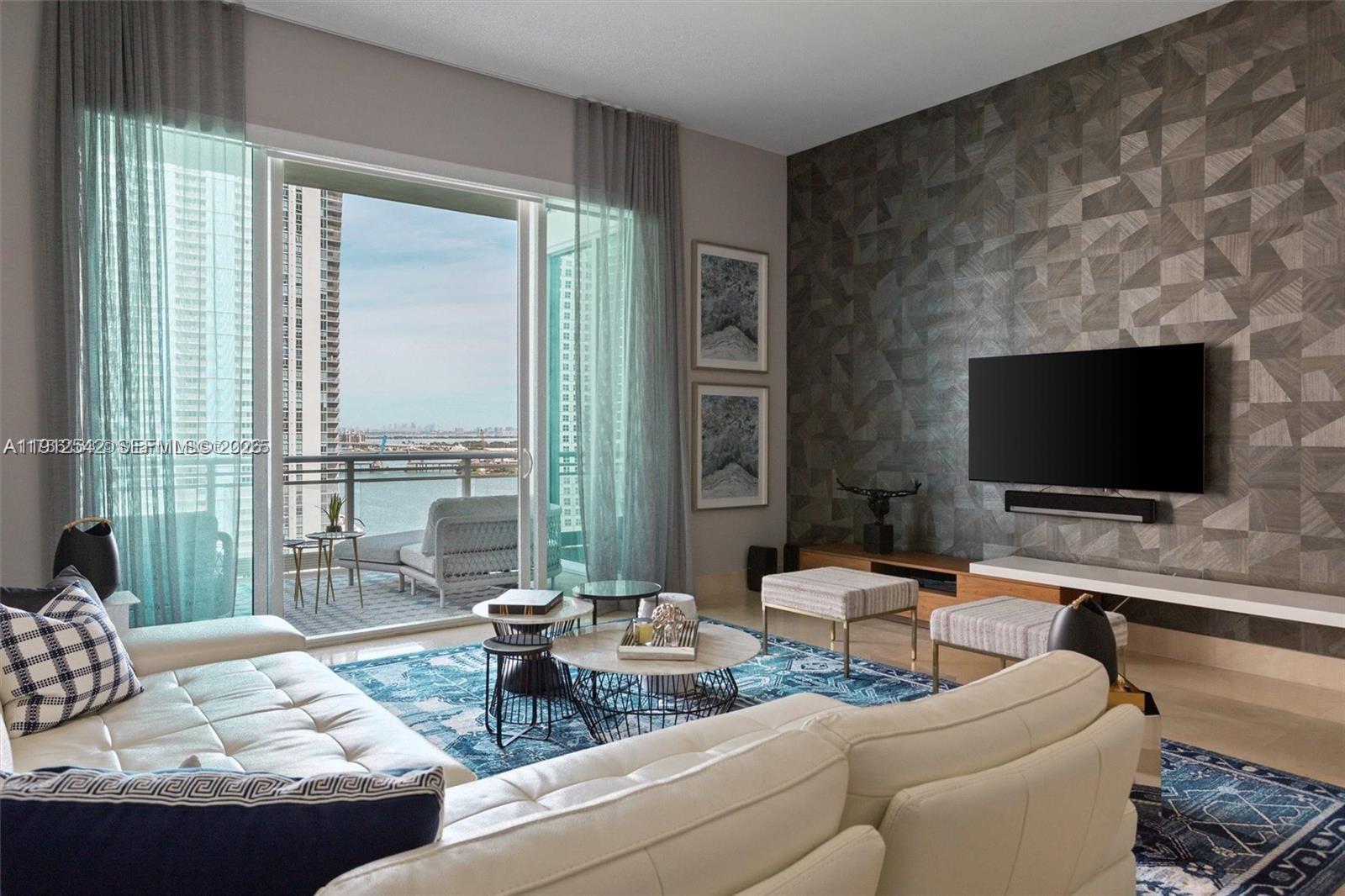 900 Brickell Key Boulevard, Unit 1502 Miami, FL 33131 - Photo 8 of 33 a living room with furniture and a flat screen tv