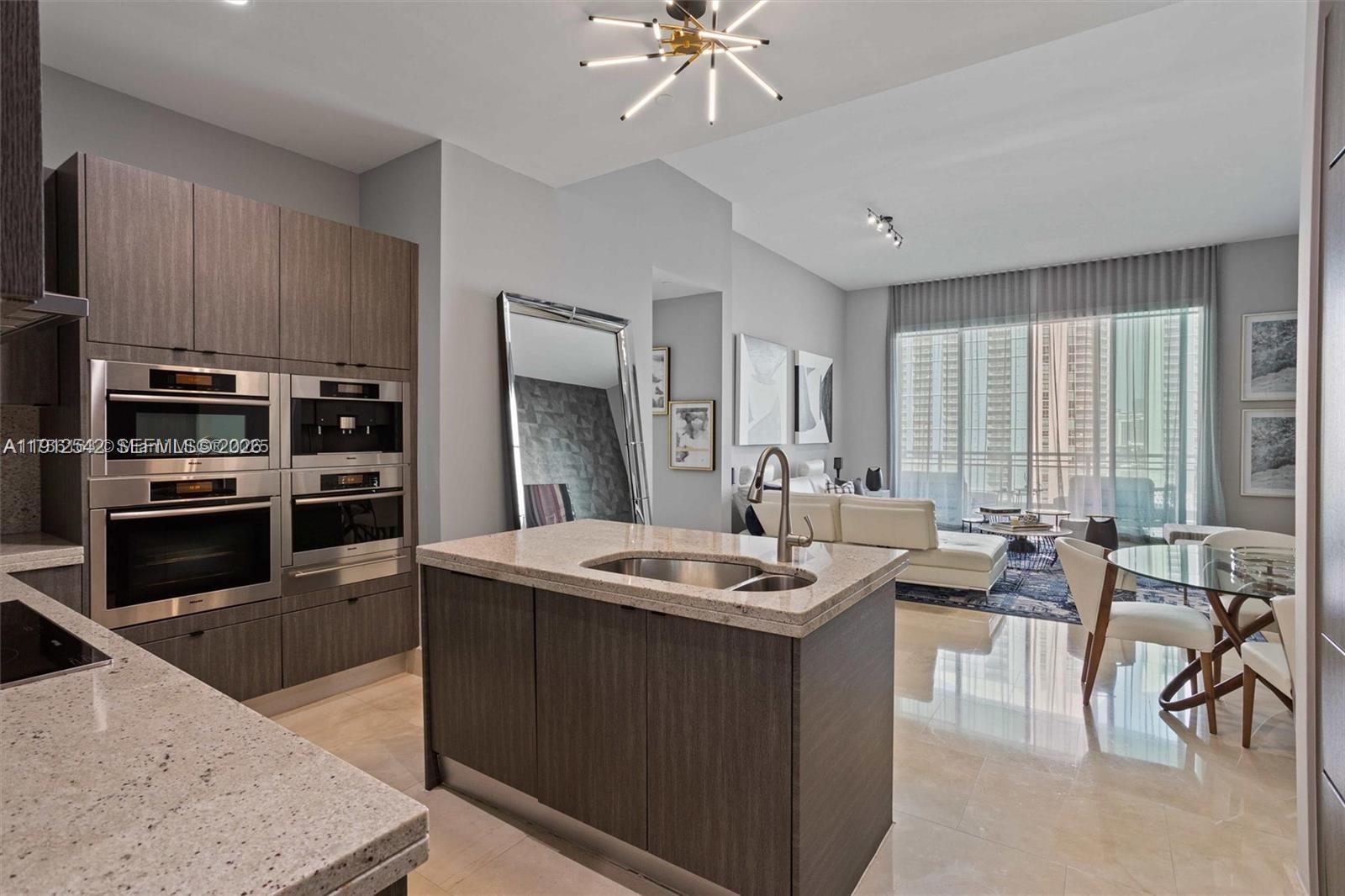 900 Brickell Key Boulevard, Unit 1502 Miami, FL 33131 - Photo 9 of 33 a kitchen with a stove a sink and a refrigerator