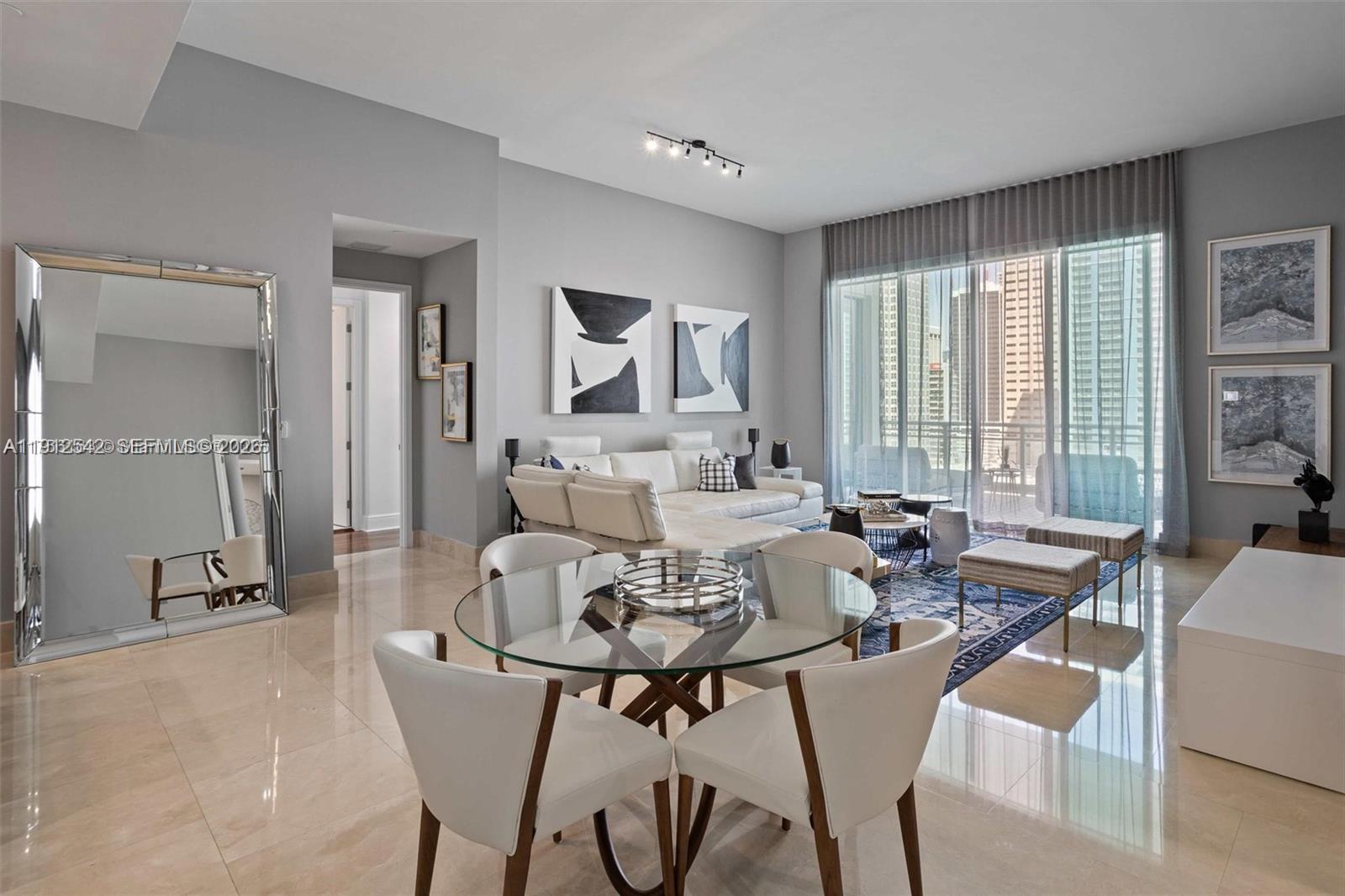 900 Brickell Key Boulevard, Unit 1502 Miami, FL 33131 - Photo 10 of 33 a view of a dining room with furniture and a large window