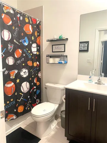 a bathroom with a sink a toilet and a shower curtain