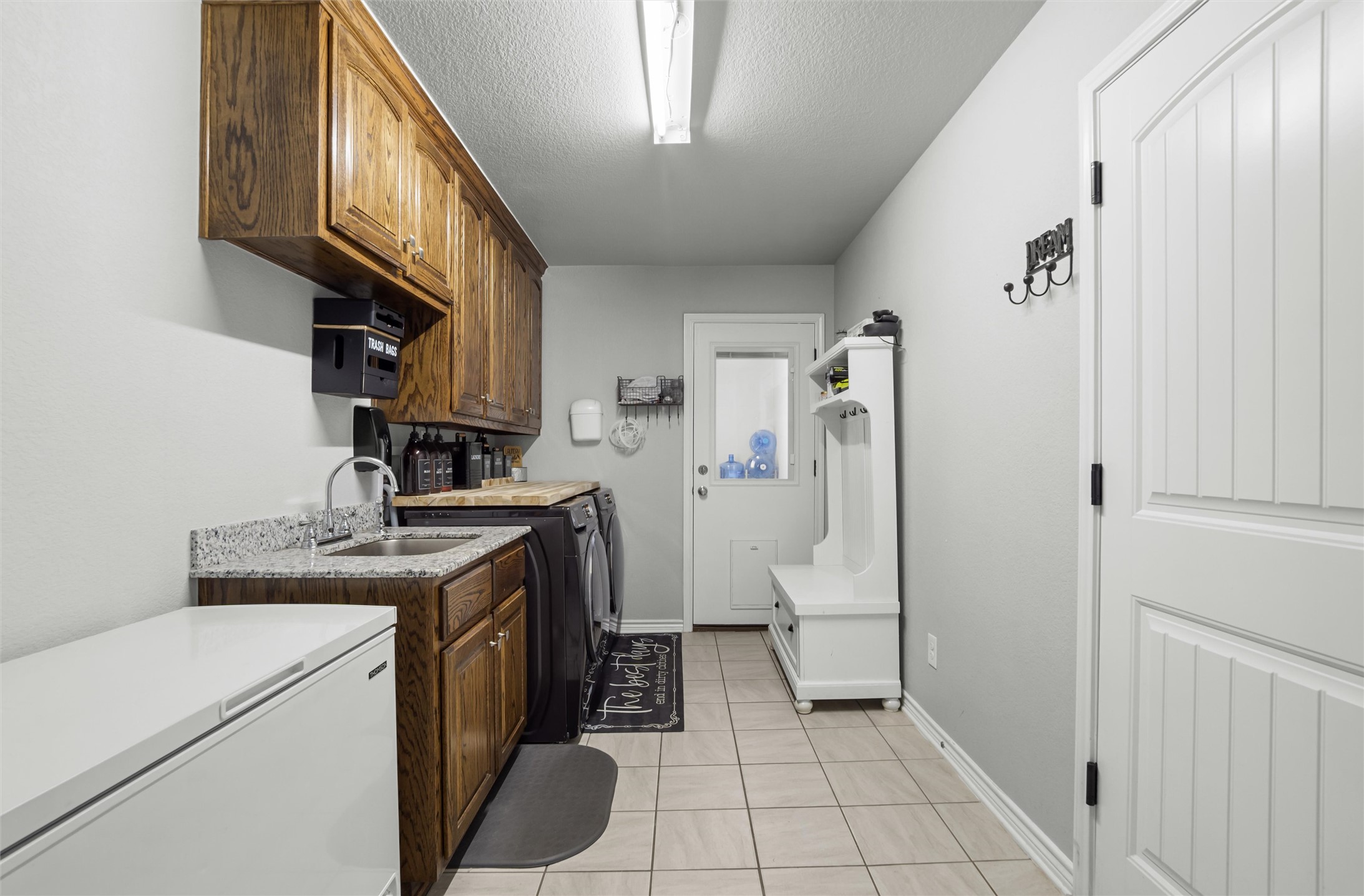 16017 Toby Court Temple, TX 76502 - Photo 22 of 33 Laundry room with light tile patterned floors, a textured ceiling, and washer and dryer