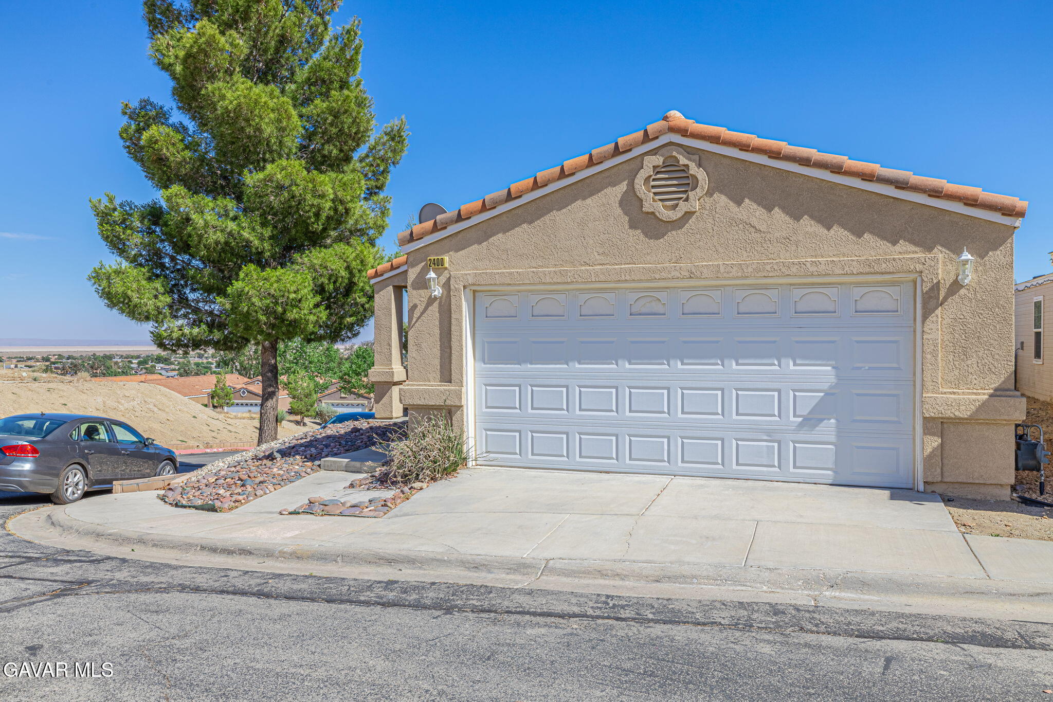 2400 Sunset Ridge Drive Rosamond, CA 93560 - Photo 4 of 34 a front view of a house with a yard and garage