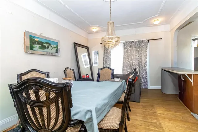 a view of a dining room with furniture a chandelier and wooden floor