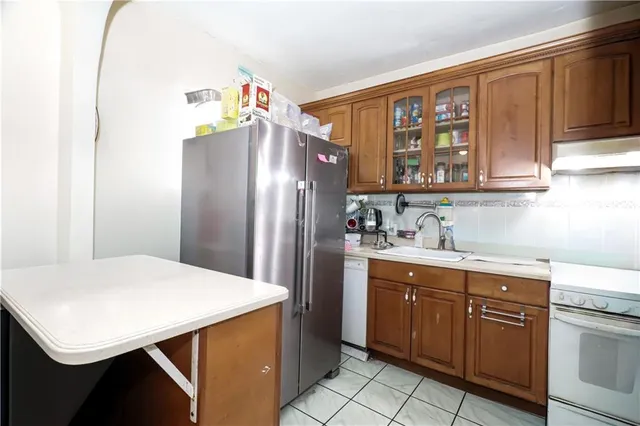 a kitchen with a refrigerator a sink dishwasher and cabinets