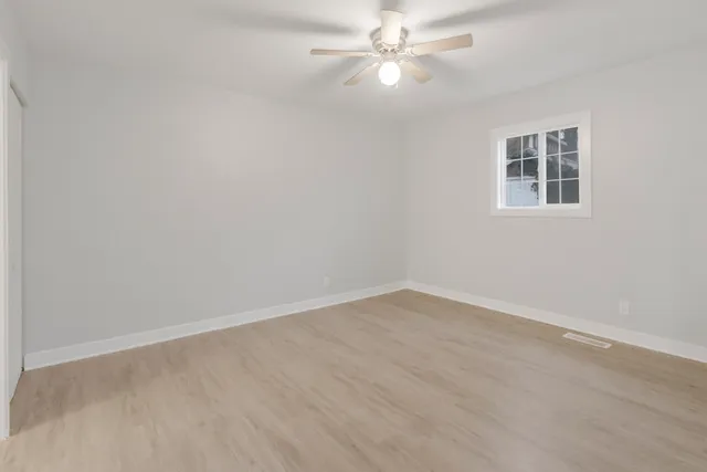 an empty room with a chandelier fan