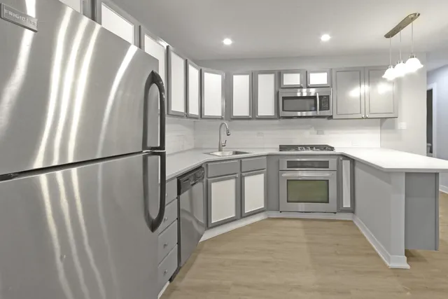 a kitchen with stainless steel appliances granite countertop a refrigerator a sink a stove and oven