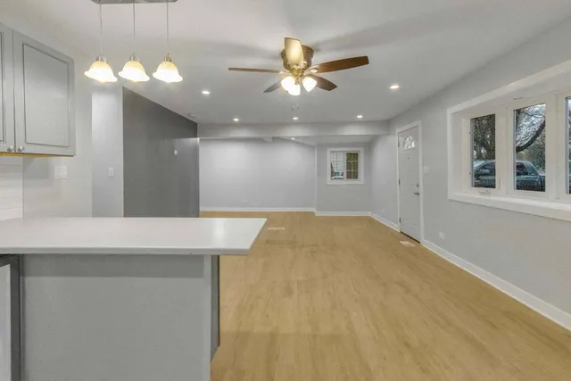 a view of an empty room with a chandelier fan