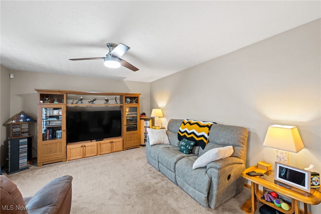 7939 Giddings Road Rootstown, OH 44272 - Photo 14 of 41 Carpeted living room with ceiling fan