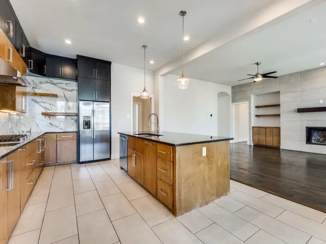 a kitchen with stainless steel appliances a refrigerator and a stove top oven